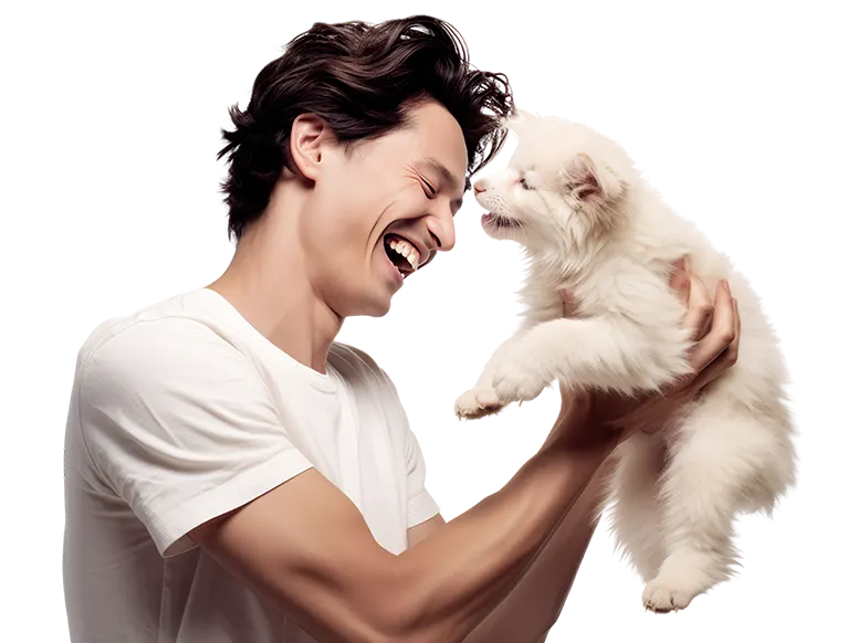 Smiling man holding up a white puppy